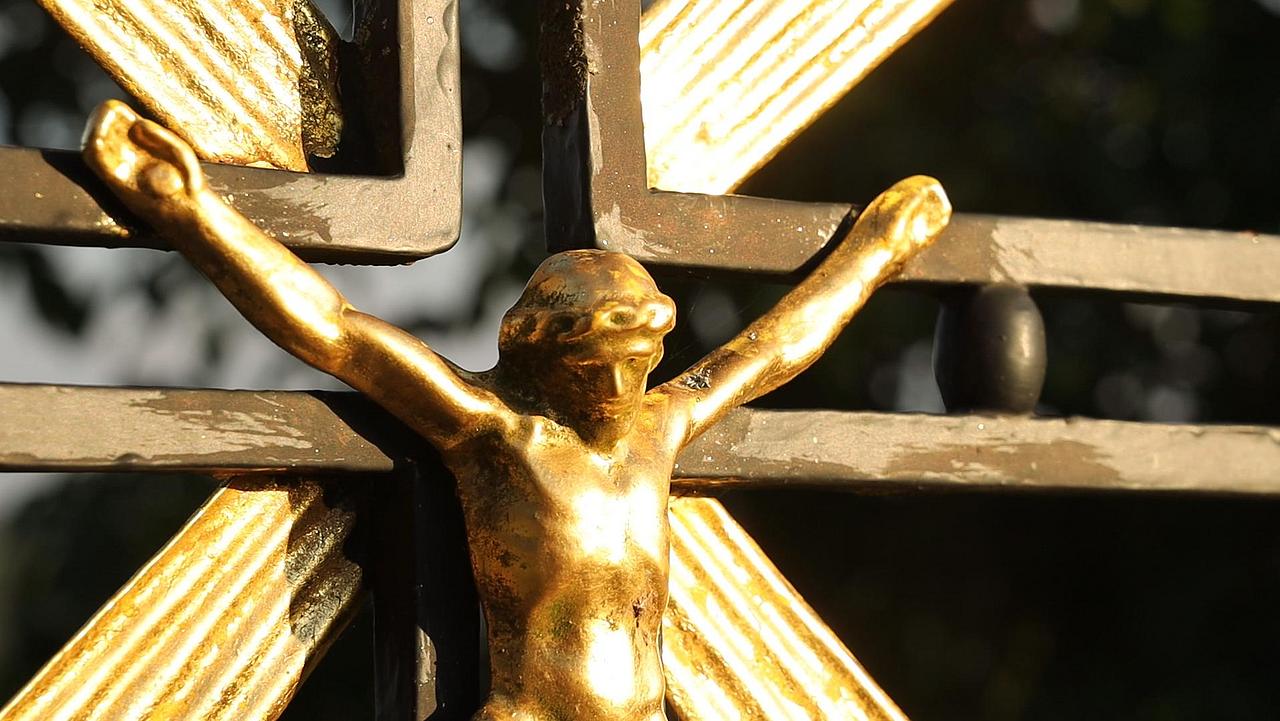 Goldenes Jesuskreuz mit dunklem Hintergrund